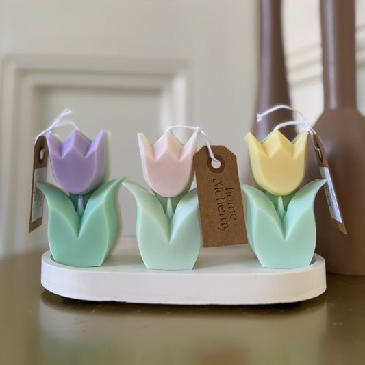 Three pastel tulip candles in soft pink, purple, and yellow — unscented, soy wax